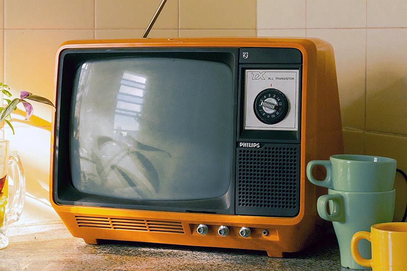 old, small orange television on a counter