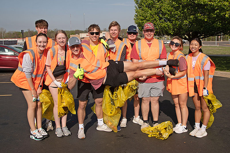 group of ten smiling college students preparing to pick up trash