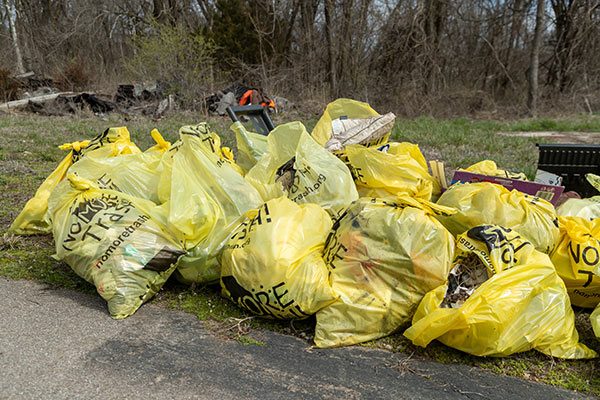 several filled yellow trash bags